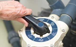 Technician adjusting a pool pump multiport valve